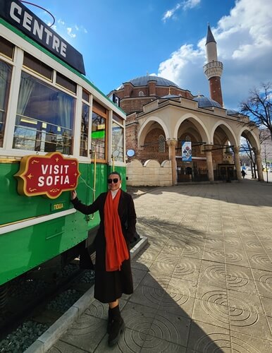 Kezban Özcan Sofya’da Banya Başı Camii önünde Visit Sofia tramvayı yanında